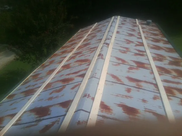 Rusted metal roof panels with new wood purlins before replacement — Storm Damage Roof Repair in Defuniak Springs by Roofing Brothers