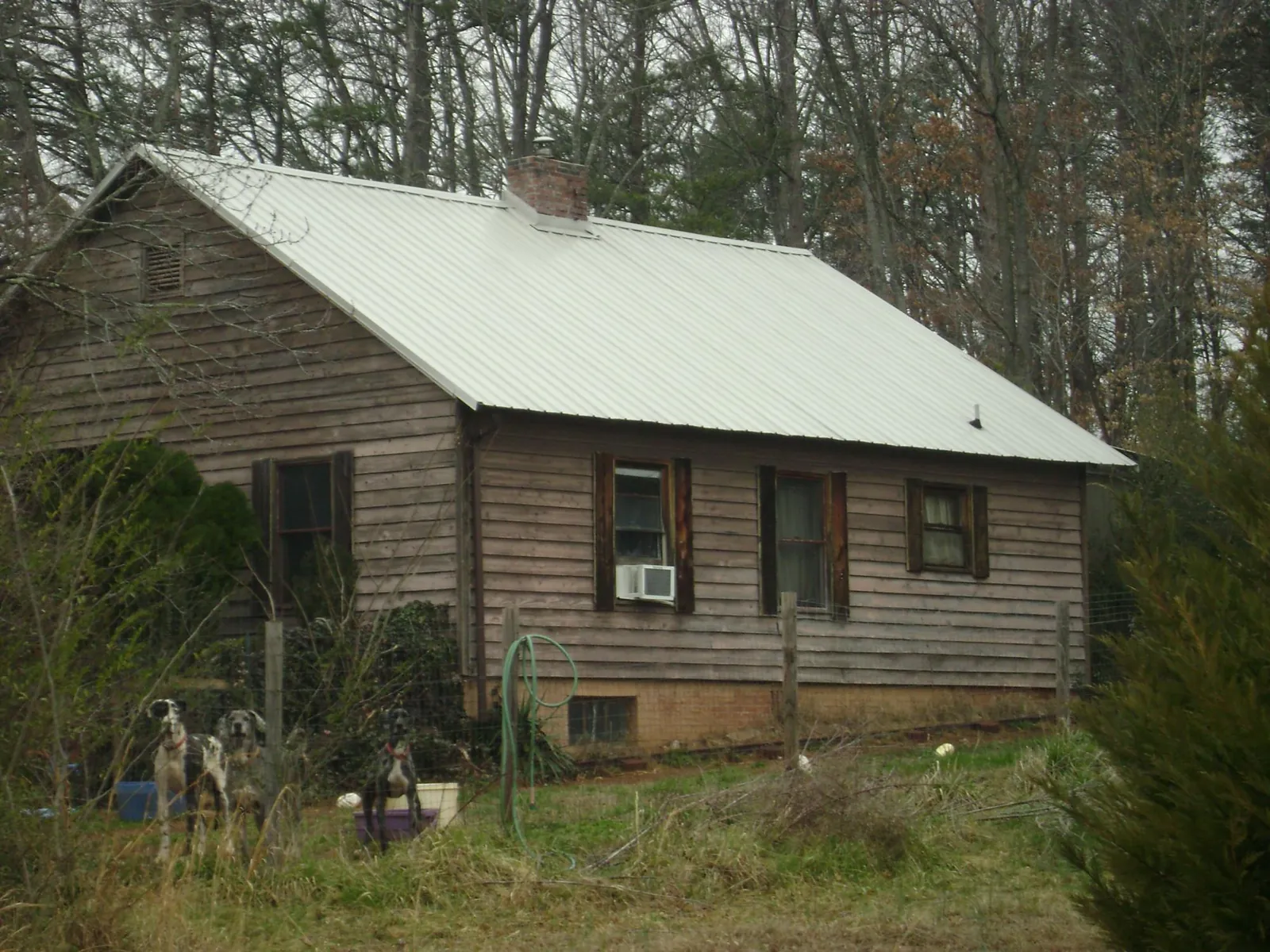 White metal roof on an old wood sided farmhouse, from a Metal Roof Installation job in Defuniak Springs